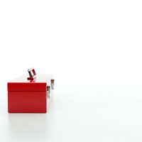 Red gift box with white ribbon and bow isolated on white background for holiday celebrations and special occasions.