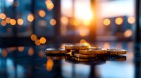 Golden coins on reflective surface with blurred bokeh lights and sunset background create atmospheric financial wealth composition with warm evening glow.