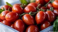 Fresh ripe cherry tomatoes with green stems in a white container, ready for cooking, salads, or culinary use.