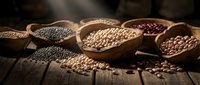 Assorted legumes and seeds in wooden bowls on rustic table, including lentils, chickpeas, and beans for cooking and nutrition.
