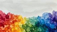 Abstract rainbow geometric mosaic with colorful polygonal shapes creating vibrant spectrum gradient from red to purple on light background.