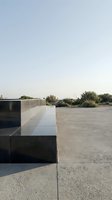 Modern concrete architectural structure with minimalist design on empty paved plaza, featuring clean lines and geometric forms for contemporary building and urban design projects.