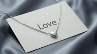 Silver heart pendant necklace on a love card against gray satin fabric, romantic gift concept for Valentine's Day or anniversary.