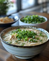 Creamy chicken and rice soup garnished with fresh chopped green onions in ceramic bowl, comfort food photography with natural window lighting.