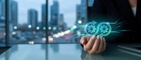Businessman holding glowing gear icons with city skyline background, representing digital transformation, automation, and industrial technology solutions for business operations.