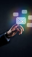 Male hand in business suit touching glowing neon envelope icon among floating mail symbols on dark background. Concept for email communication, digital messaging, and business correspondence.