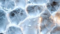 Macro shot of melting ice cubes with warm light shining through transparent frozen water crystals creating abstract pattern of cracks and bubbles. Artistic cold background.