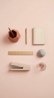 Stylish office supplies arranged on pink background including geometric pen holder, gold pen, notebook, ruler, stapler and paper clips for workspace design.
