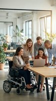 Diverse business team collaborating in modern office with disabled woman in wheelchair working together on laptop project in bright workspace.
