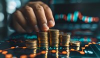 Male hand stacking golden coins on dark background with financial charts and data visualization. Focus on wealth growth and investment strategy planning.
