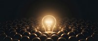 Glowing light bulb standing out among dark bulbs, symbolizing innovation, creativity, unique ideas, and competitive advantage in business and technology.