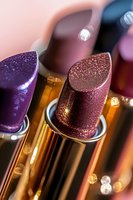 Luxurious glitter lipsticks in purple and rose gold shades with metallic packaging captured in macro photography with soft bokeh lights creating glamorous makeup atmosphere.