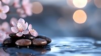 Zen spa stones with delicate cherry blossom flowers on water surface creating peaceful meditation atmosphere with soft bokeh lights background.