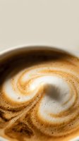 Closeup of latte art with swirled espresso and steamed milk foam in ceramic cup, suitable for coffee shop menus, cafes, and beverage marketing materials.