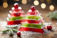 Festive watermelon and lime jelly layers shaped as Christmas trees, decorated with red baubles and pine branches on wooden surface with bokeh lights background.
