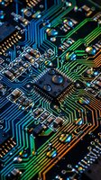 Close-up macro view of computer circuit board with colorful electronic pathways, microchips and components for technology and engineering concepts.