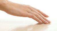 Woman's hand with manicured nails resting on white surface, showcasing skincare, beauty treatments, wellness and cosmetic products for advertising purposes.