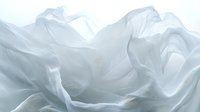 Ethereal white fabric flowing in gentle waves creates soft, dreamy texture with delicate folds and graceful movement, suitable for luxury fashion and wedding designs.