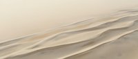 Aerial view of desert sand dunes with flowing wave patterns and natural ridges, showcasing arid landscape textures for travel and nature projects.