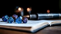 Glowing blue and purple polyhedral dice set on open notebook with blurred background, creating magical gaming atmosphere for tabletop roleplaying games.