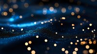 Glowing particles flow across digital wave surface with blue and golden bokeh lights, representing data stream, technology network, and digital transformation for tech backgrounds.