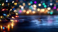 Christmas lights with colorful bokeh background on dark wooden surface creating festive holiday atmosphere for seasonal decorations and celebrations.