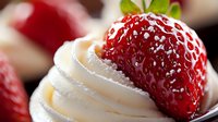 Fresh ripe strawberry topped with sweet whipped cream and powdered sugar on dark background, macro food photography for dessert menu and recipe blogs.