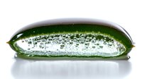 Fresh green jalapeno pepper slice with water droplets and bubbles on white background, macro photography showing texture and transparency details.
