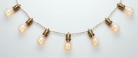 Decorative string lights with vintage-style amber glass bulbs and brass fixtures suspended on wire, perfect for events, home decor, and interior design projects.