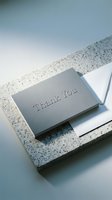 Elegant gray embossed thank you card with white envelope on granite surface, minimal style for wedding, business, or personal gratitude stationery.