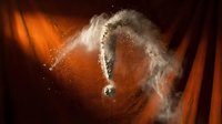 Abstract question mark formed by white powder explosion against dramatic orange and black background with dynamic lighting effects.