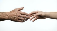 Elderly and young hands reaching toward each other in caring gesture symbolizing intergenerational connection, family support and compassion on white background.