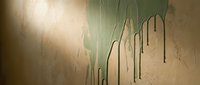Young woman with fair skin and blonde hair wearing casual clothing, standing against weathered wall with green peeling paint and dripping water streaks, suitable for editorial, lifestyle, and artistic projects.