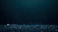 Underwater particles floating in dark blue ocean depths with light reflections and bokeh effect creating mysterious marine atmosphere. Suitable for nature backgrounds.