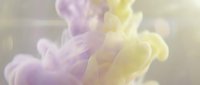 Soft purple and yellow ink swirling in water, creating dreamy abstract cloud shapes with gentle light bokeh effect.