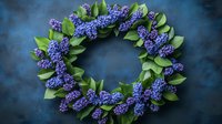 Decorative wreath made with purple lilac flowers and green leaves arranged in circular shape against dark blue textured background. Suitable for spring celebrations.