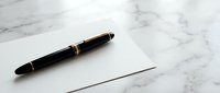 Elegant black fountain pen with gold accents resting on blank white paper against marble surface for business writing and professional correspondence.