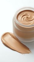 Luxury foundation cream in glass jar with smooth swirl texture and makeup smear on white background for cosmetic advertising and beauty product marketing.