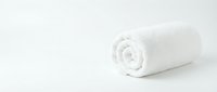 Rolled white towel on isolated white background, ready for spa, hospitality, hotel, and wellness design projects.