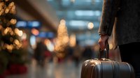 Professional businessman with suitcase walking through modern airport terminal with bokeh lights creating atmospheric travel scene for business concepts.
