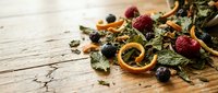 Herbal tea blend with dried fruits and berries on rustic wooden background for healthy lifestyle and natural wellness concepts.