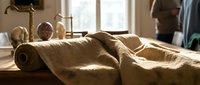 Spa massage table with rolled towels and natural lighting creating relaxing wellness atmosphere for therapeutic treatments and holistic healing.