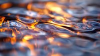 Mesmerizing orange flames dance across dark rippling water surface creating dramatic light reflections and abstract patterns in moody atmospheric scene.
