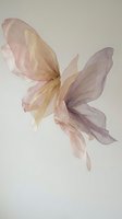Delicate watercolor butterfly with translucent wings in soft pink and purple hues on neutral background for feminine design projects.