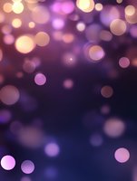 Dreamy purple and pink bokeh lights floating on dark background create magical atmosphere for festive designs, holiday cards and romantic backgrounds.