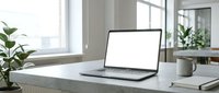 Modern laptop with blank white screen on minimalist desk workspace with plants and coffee mug in bright office interior for mockup presentations.