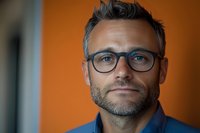 Professional middle-aged Caucasian businessman with glasses and beard in modern office setting for corporate marketing and business presentations.