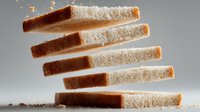 Sliced bread loaf with white and brown parts arranged in staggered formation on gray background, showing texture and freshness for food advertising.