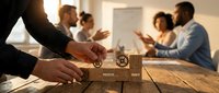 Business team collaboration with wooden puzzle pieces symbolizing teamwork and problem-solving in modern office environment during strategic meeting.