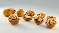 Whole and cracked walnuts with kernels isolated on white background, suitable for food, nutrition, and healthy eating design projects.
